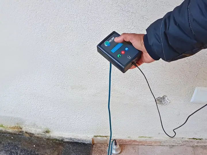 Sensor do geofone apoiado no piso de uma área externa perto do ralo