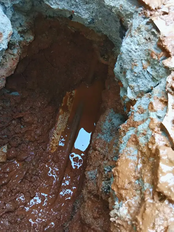 Água acumulada sob o piso: Abertura localizada mostra a água sob o contrapiso e o trecho que vazava.